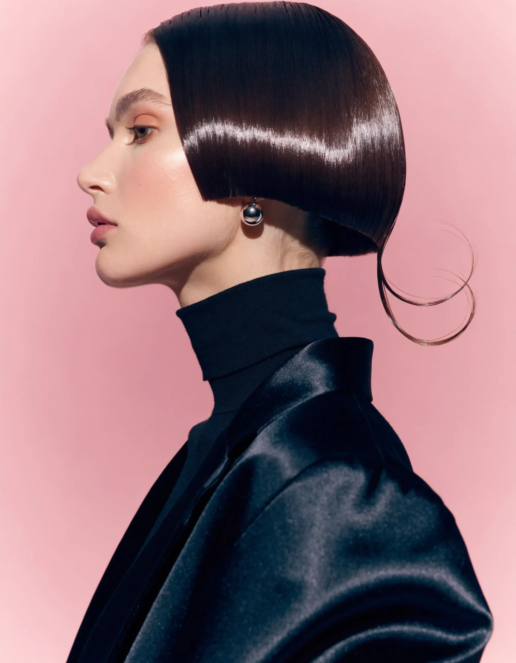 Coiffeuse ajustant une coupe mi-longue sous la lumière douce du salon