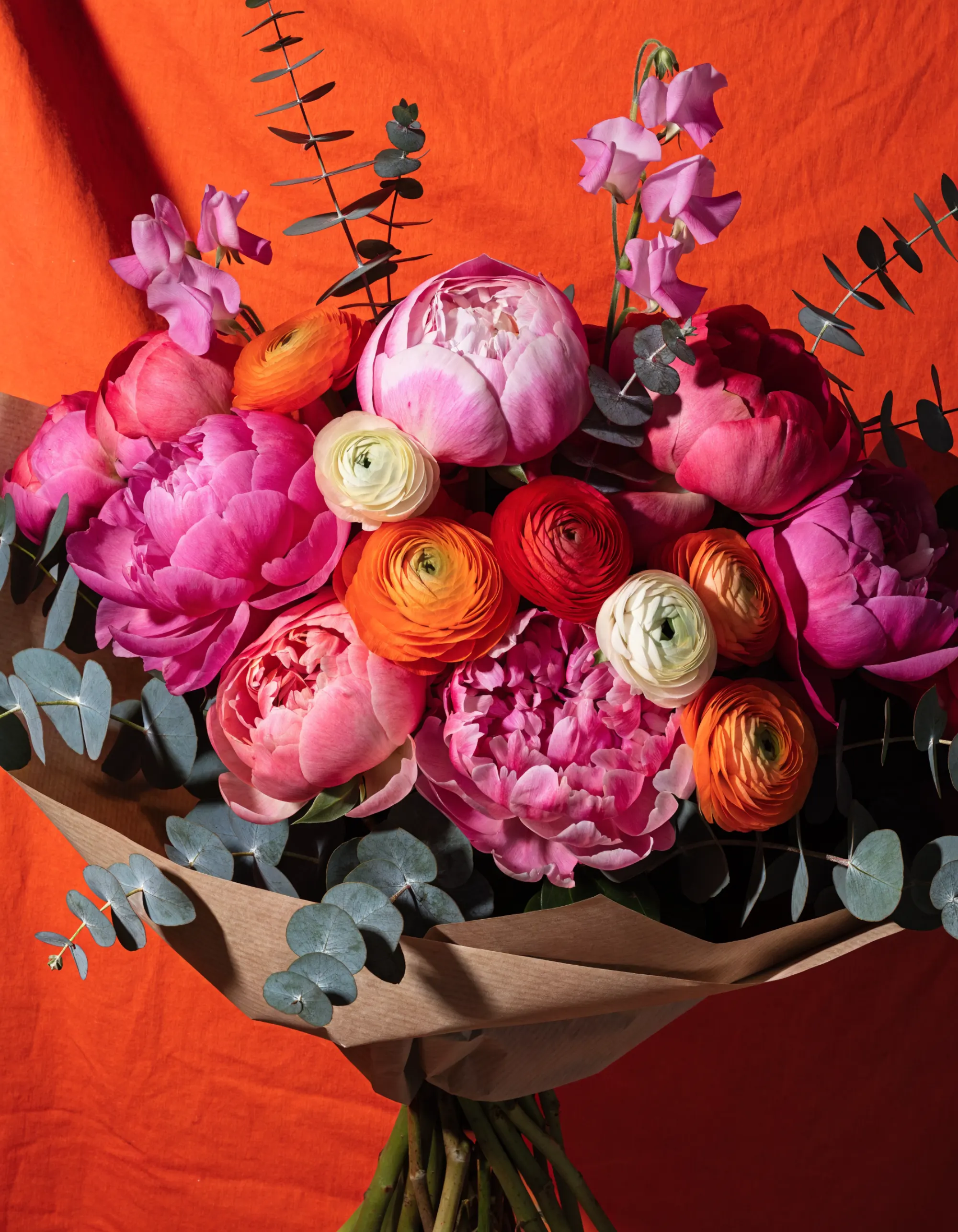 Bouquet du jour noué de raphia : dahlias orangés, cosmos prune et branches d'eucalyptus