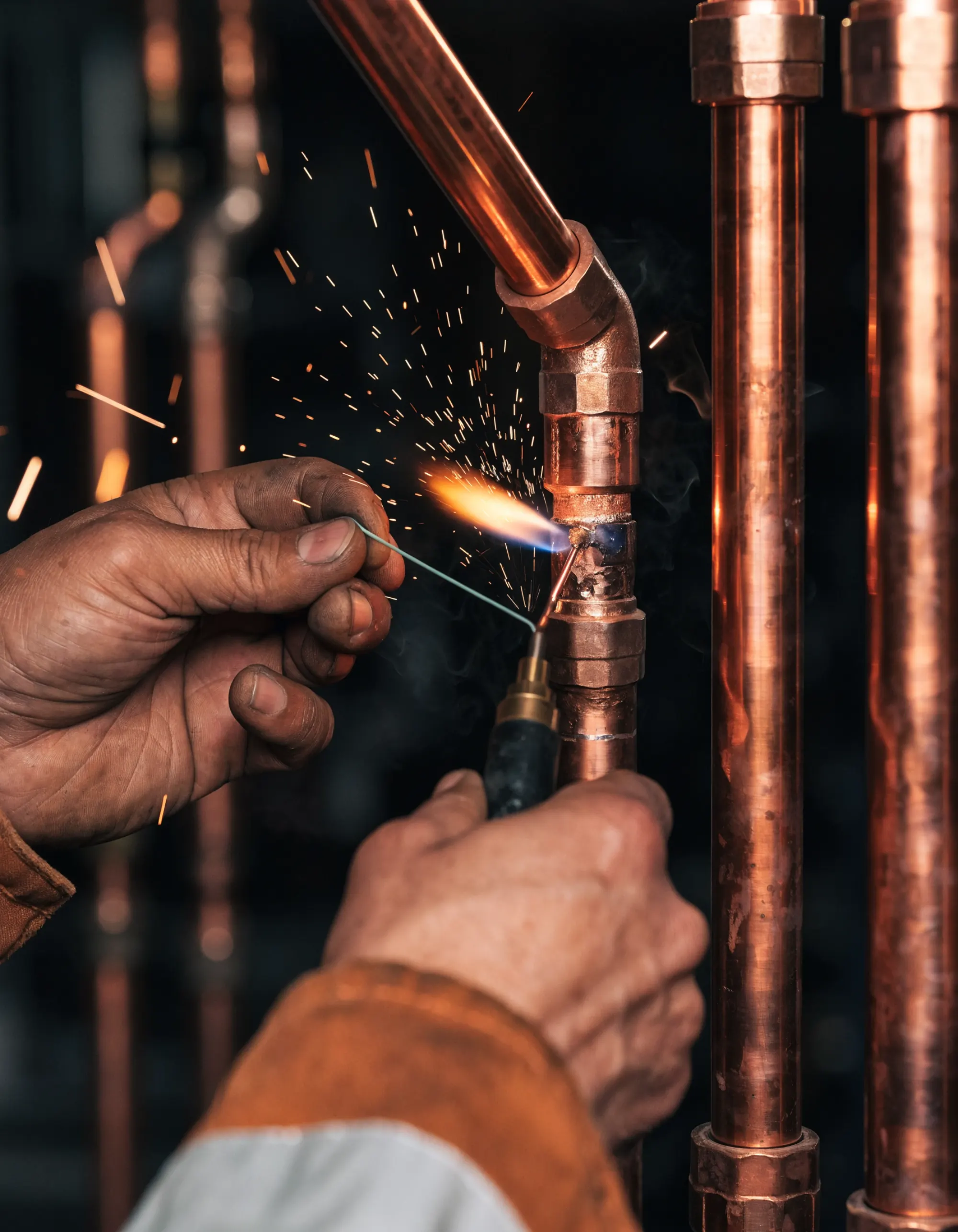 Artisan de l’équipe Flux ajustant un raccord sur un chantier